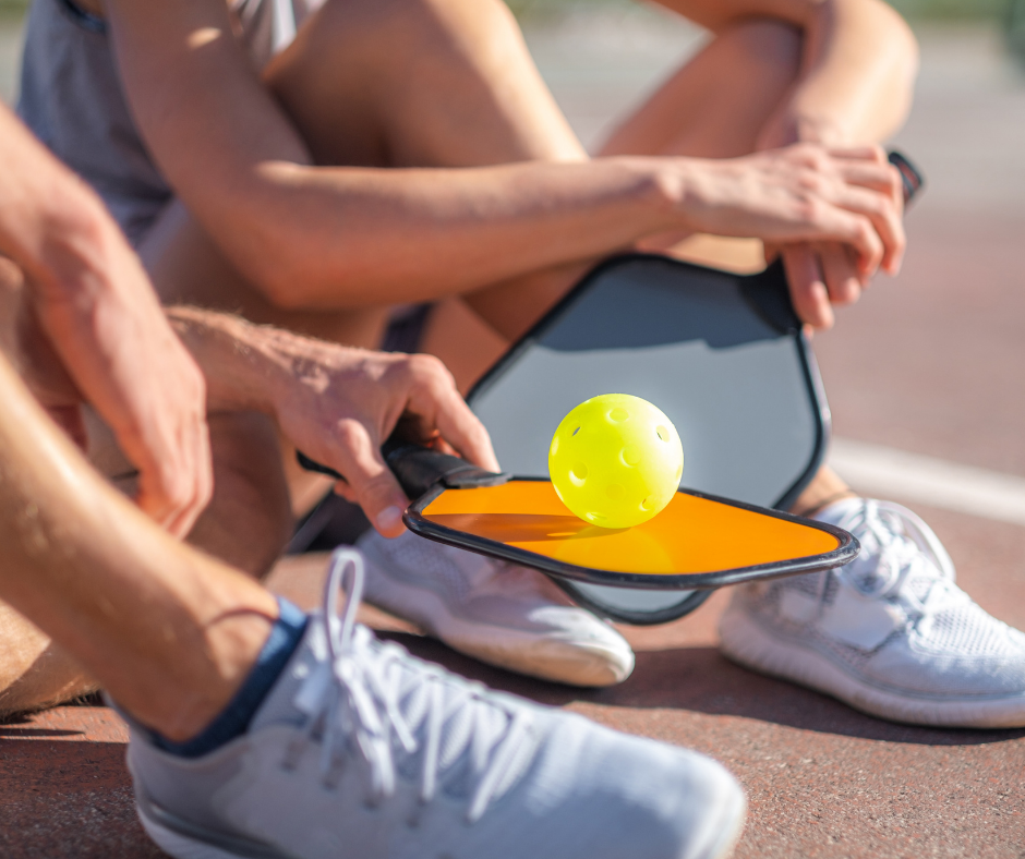 two people holding paddles and ball